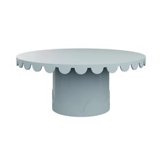 a white table with scalloped edges and a circular top on the base is shown