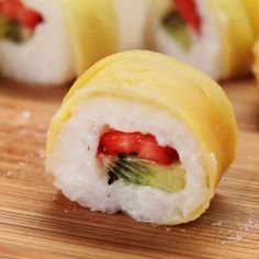 some sushi rolls are sitting on a cutting board