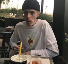 a man sitting at a table with donuts in front of him and a drink