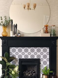 a living room with a fire place, mirror and potted plants on the mantle