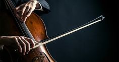 a person playing an instrument on a black background with their hands resting on the strings