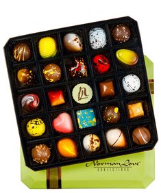 a box filled with assorted chocolates sitting on top of a table