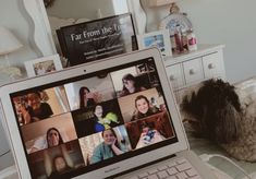 an open laptop computer sitting on top of a bed next to a dresser and mirror