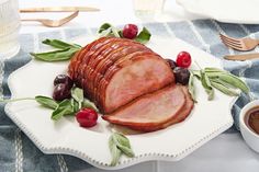 a ham is on a plate with olives and cherries