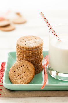 cookies and milk are on a tray with red and white striped straws next to it