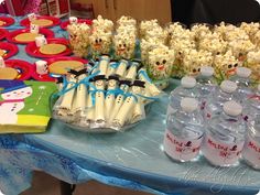 a table topped with lots of water bottles and snacks