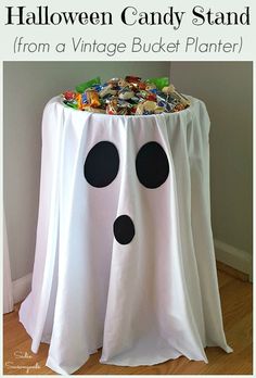 a table that has some candy in it and is decorated like a ghost with black polka dots