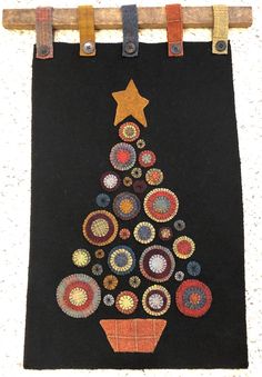 a christmas tree is hanging on a clothes line with buttons and stars in the shape of circles