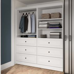 an open closet with white drawers and clothes hanging on the doors, next to a wooden floor