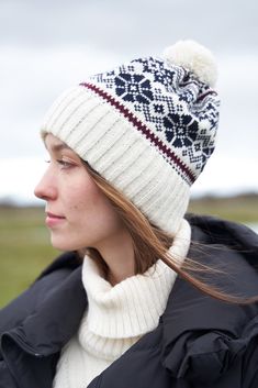 Wool is known for its excellent insulation properties, and it's a natural, sustainable material. This makes the hat both warm and eco-friendly. The hat's design is inspired by classic Estonian winter traditions, ensuring it retains warmth and keeps you comfortable in cold weather. Features a pompom. - 100% wool - Unisex -  Winter jacquard SKU CODE:  VM-117 Warm Winter Bonnet With Curved Brim, Warm Nordic Hats For Outdoor, Nordic Style Warm Outdoor Hats, Warm Nordic Beanie For Outdoor, Nordic Style Winter Hat For Outdoor Activities, White Winter Hats For Cold Weather, Outdoor White Knitted Hats, White Brimmed Beanie For Winter, Cream Winter Hats For Cold Weather