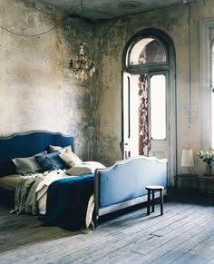 a bed sitting in the middle of a bedroom next to a window