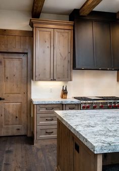 a kitchen with wooden cabinets and marble counter tops