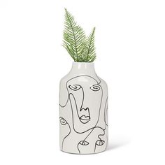 a white vase with a plant in it