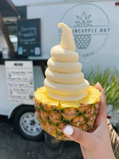 a person holding up a pineapple ice cream cone