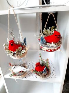 three red birds sitting on top of white shelves