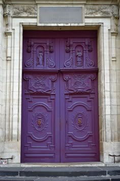 an old building with two large purple doors