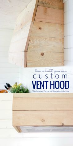 a wooden vent hood with the words custom vent hood written on it in blue and white