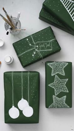 green wrapping paper with white designs on it and other crafting supplies next to them