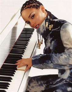 a woman sitting at a piano with her hand on the keys