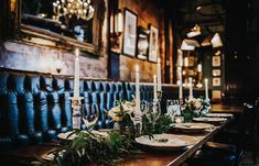 a long table with plates and candles on it