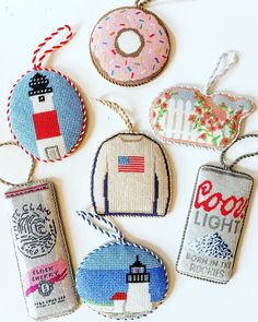 six embroidered tags with different designs hanging from strings on a white surface, one has a donut and the other has an american flag