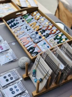 the table is covered with lots of crafting supplies and crafts like buttons, beads, and necklaces