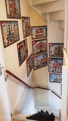 there are many pictures on the wall next to the stair case in this house that is decorated with legos