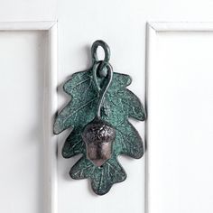 a door handle with a leaf and acorn hanging from it