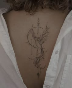 the back of a woman's neck with a bird tattoo on it