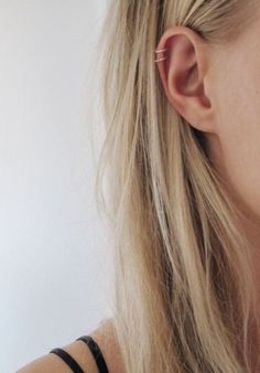 a close up of a person wearing ear clips