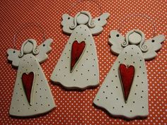 three white angels with red hearts on them