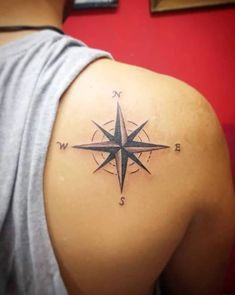 a man with a compass tattoo on his shoulder