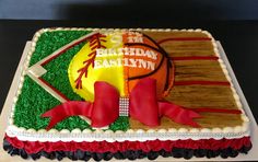 a sports themed birthday cake with red ribbon and bow on the side, decorated in green grass