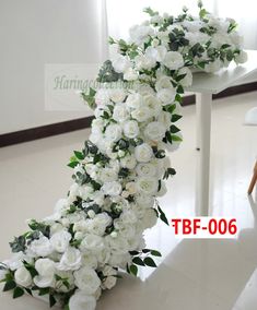 white flowers are arranged in the shape of a wedding arch