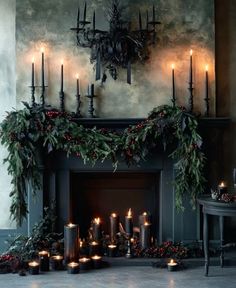 a fireplace decorated with candles and greenery