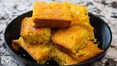 a black bowl filled with cornbreads on top of a table