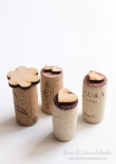 four wine corks with hearts on them sitting next to each other in front of a white background