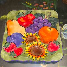 a glass plate with fruit and vegetables painted on it