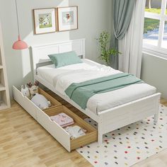 a white bed with drawers underneath it in a room