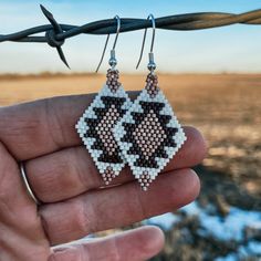 someone is holding up their handmade earrings