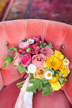 a bouquet of flowers sitting on top of a pink chair