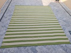 a large green and white striped rug on the ground