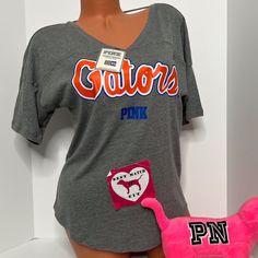 New With Tags Victoria’s Secret Pink Collegiate Collection University Of Florida Uf Gators T-Shirt Cut Out Logo Size Extra Small No Offers Please Sporty V-neck T-shirt For Loungewear, Trendy V-neck Sports Top, Casual V-neck Top For College, Sporty V-neck T-shirt, Sporty V-neck Loungewear T-shirt, Sporty V-neck Tops For Loungewear, Game Day V-neck Top With Letter Print, V-neck Game Day Top With Letter Print, V-neck Graphic Print Top For Game Day