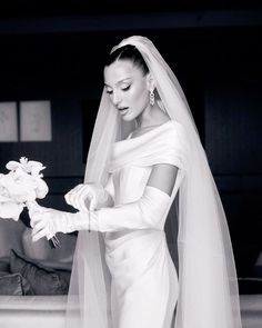 black and white photograph of a woman in a wedding dress with flowers on her finger