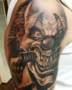 a close up of a person with a tattoo on his arm and shoulder, wearing a clown mask