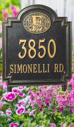 a black and gold sign in front of some purple flowers with the number 350 on it