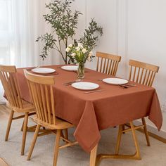 a dining room table set for four with plates and utensils on the table