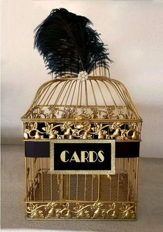 a gold birdcage with a black and white label on it that says cards