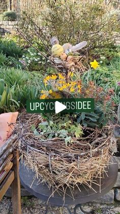 a bird's nest is sitting on top of a planter filled with flowers