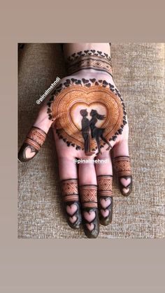 the hands and feet of a woman are decorated with henna tattoos, which is shaped like a heart